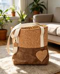 Cork and faux suede tote bag held by hand showing heart applique and canvas handles