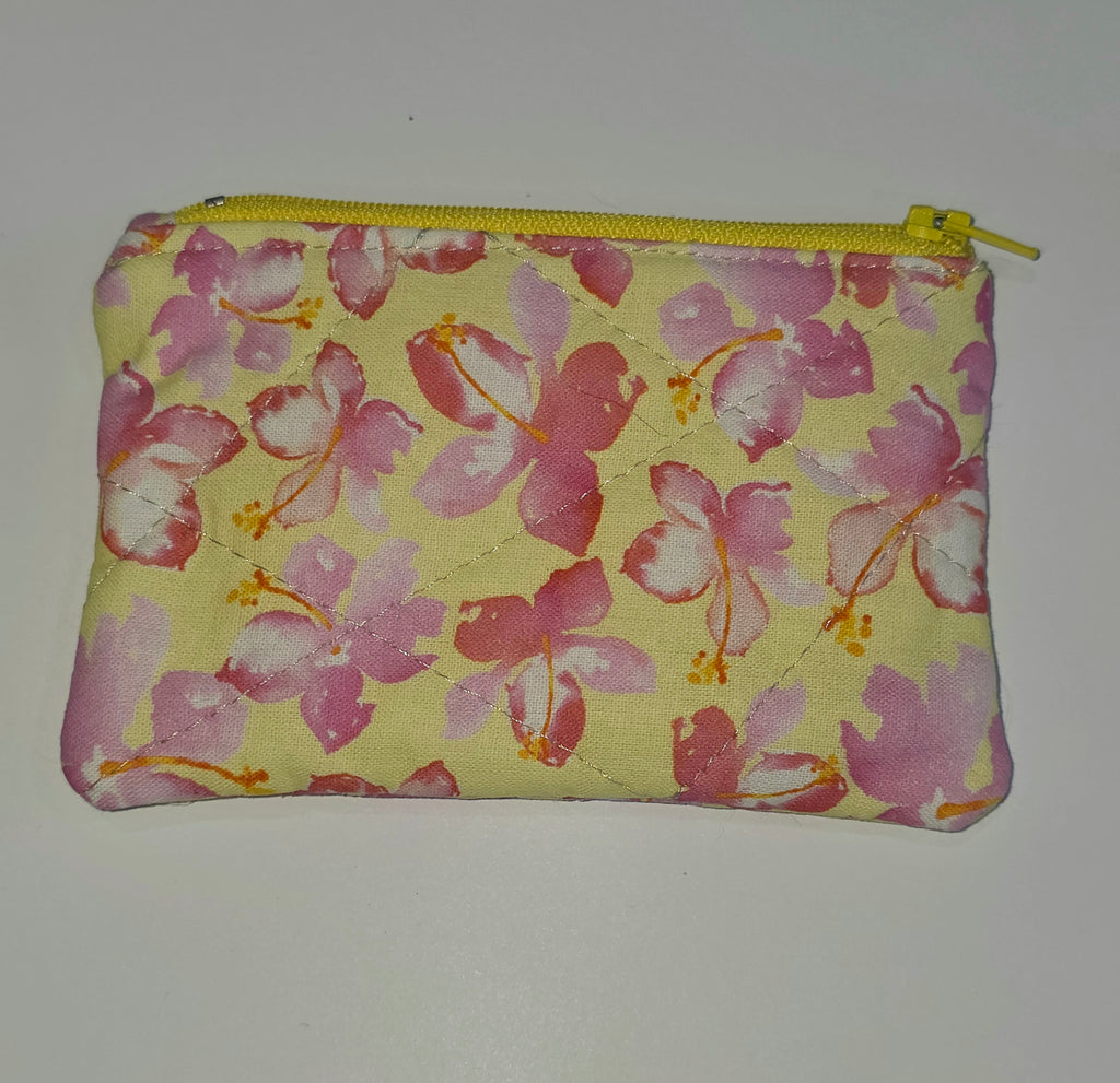 Floral-patterned pouch with a yellow zipper on a white background